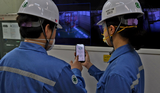 포스코 직원들이 스마트 세이프티 볼과 연계된 휴대폰 앱을 통해 밀폐공간 출입전 가스 농도를 사전 확인하고 있다. <포스코 제공>